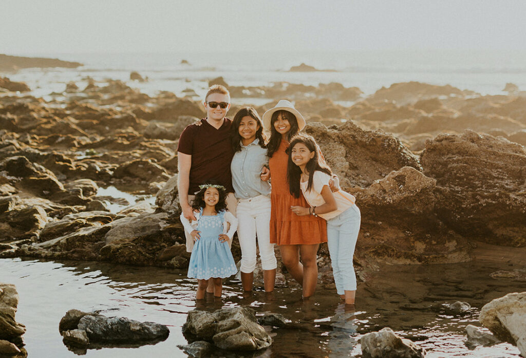 A family of 5 standing in a creek