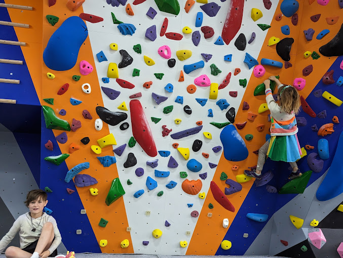 Bright, stripy walls filled with holds and two little girls