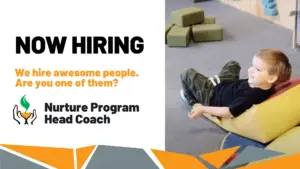 NOW HIRING - We hire awesome people. Are you one of them? Nurture Program Head Coach. Smiling toddler playing with foam blocks in front of climbing wall